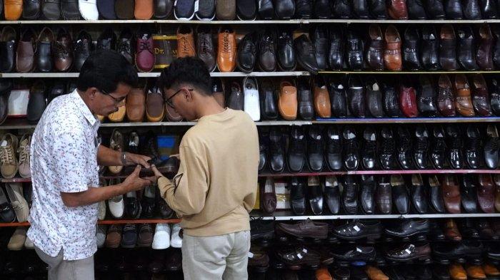 Pengunjung memilih sepatu yang dijual di salah satu toko sepatu di kawasan pertokoan sepatu Cibaduyut, Jalan Cibaduyut Raya, Kota Bandung, Jawa Barat, Sabtu (25/5/2024).