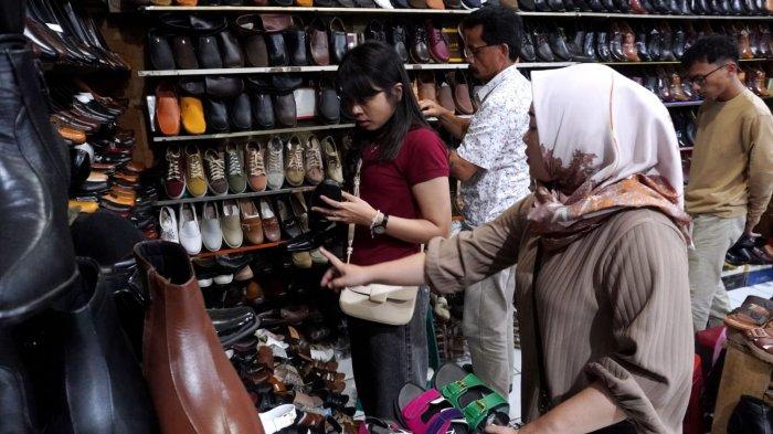Pengunjung memilih sepatu yang dijual di salah satu toko sepatu di kawasan pertokoan sepatu Cibaduyut, Jalan Cibaduyut Raya, Kota Bandung, Jawa Barat, Sabtu (25/5/2024).