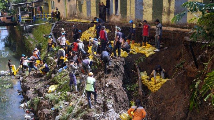 Petugas dan warga bergotongroyong membersihkan kirmir anak Sungai Cikapundung yang ambrol diterjang air bah pasca pipa PDAM pecah di Jalan Cibangkong Lor, RT 01, RW 05, Kelurahan Maleer, Kecamatan Batununggal, Kota Bandung, Jawa Barat, Kamis (6/6/2024).