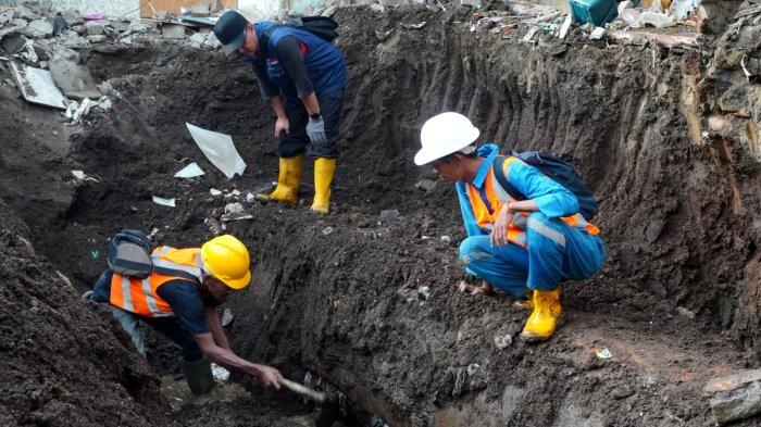 Pekerja PDAM Tirtawening menemukan retakan memanjang pada pipa PDAM yang pecah saat diperiksa di lokasi dua rumah yang hancur di Jalan Cibangkong Lor, RT 01, RW 05, Kelurahan Maleer, Kecamatan Batununggal, Kota Bandung, Jawa Barat, Kamis (6/6/2024).