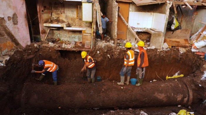 Pekerja PDAM Tirtawening menggali tanah untuk memeriksa pipa PDAM yang pecah di lokasi dua rumah yang hancur di Jalan Cibangkong Lor, RT 01, RW 05, Kelurahan Maleer, Kecamatan Batununggal, Kota Bandung, Jawa Barat, Kamis (6/6/2024).