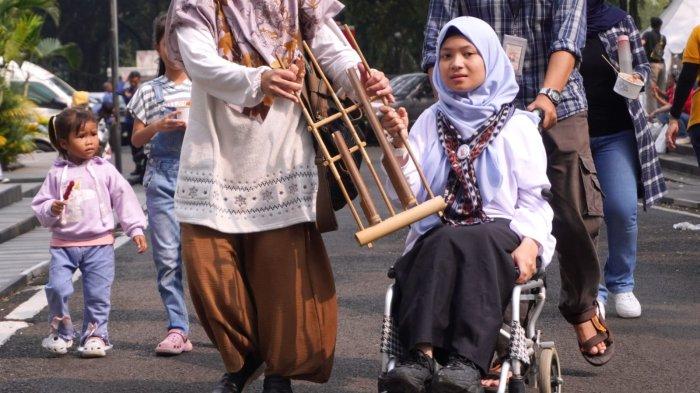 Salah seorang peserta grup angklung menggunakan kursi roda selesai tampil dalam gelaran 