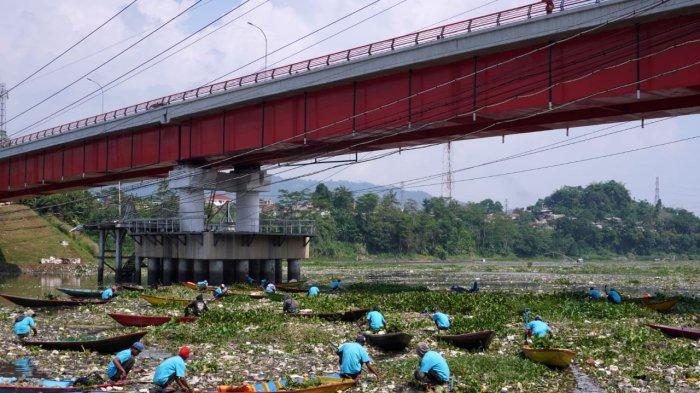Sejumlah pemulung menggunakan perahu kayu mengais sampah plastik yang bisa dijual dan memungut sampah lainnya untuk dibuang saat bersama petugas gabungan dan masyarakat bergotong royong membersihkan sampah di Sungai Citarum, Desa Selacau, Kecamatan Batujajar, Kabupaten Bandung Barat, Sabtu (14/6/2024).