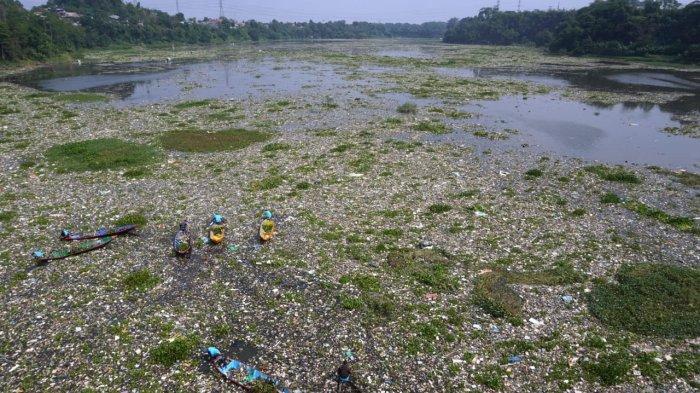 Sejumlah pemulung menggunakan perahu kayu mengais sampah plastik yang bisa dijual dan memungut sampah lainnya untuk dibuang saat bersama petugas gabungan dan masyarakat bergotong royong membersihkan sampah di Sungai Citarum, Desa Selacau, Kecamatan Batujajar, Kabupaten Bandung Barat, Sabtu (14/6/2024).