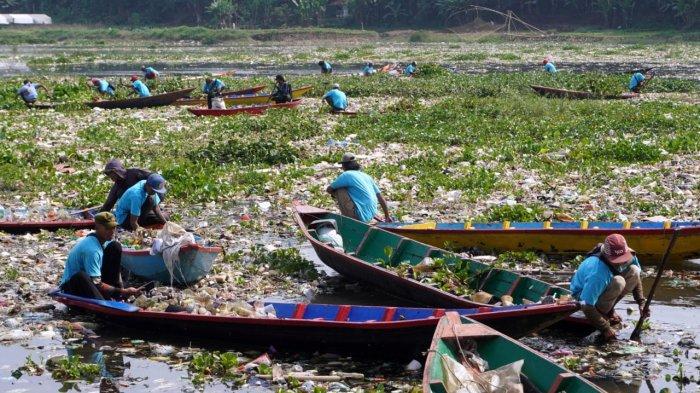Sejumlah pemulung menggunakan perahu kayu mengais sampah plastik yang bisa dijual dan memungut sampah lainnya untuk dibuang saat bersama petugas gabungan dan masyarakat bergotong royong membersihkan sampah di Sungai Citarum, Desa Selacau, Kecamatan Batujajar, Kabupaten Bandung Barat, Sabtu (14/6/2024).