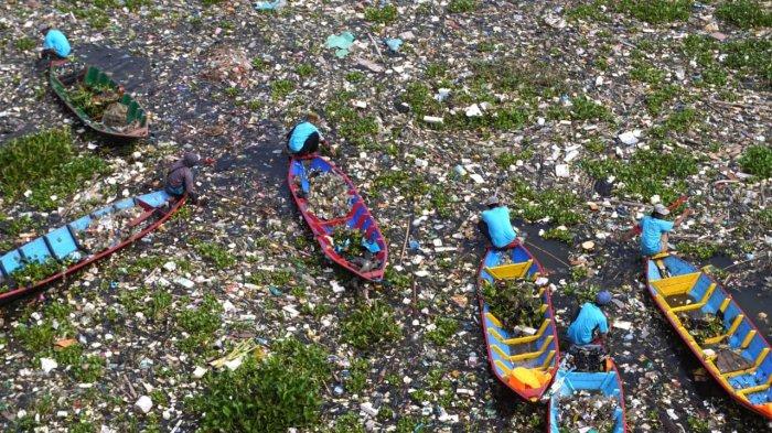 Sejumlah pemulung menggunakan perahu kayu mengais sampah plastik yang bisa dijual dan memungut sampah lainnya untuk dibuang saat bersama petugas gabungan dan masyarakat bergotong royong membersihkan sampah di Sungai Citarum, Desa Selacau, Kecamatan Batujajar, Kabupaten Bandung Barat, Sabtu (14/6/2024).