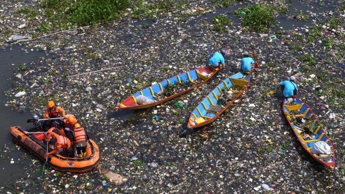 Sejumlah pemulung menggunakan perahu kayu mengais sampah plastik yang bisa dijual dan memungut sampah lainnya untuk dibuang bersama petugas gabungan di Sungai Citarum, Desa Selacau, Kecamatan Batujajar, Kabupaten Bandung Barat, Sabtu (14/6/2024).