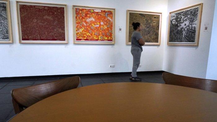Pengunjung mengamati karya seni grafis seri ‘Artileri’ dari pegrafis asal Bali, I Kadek Septa Adi, di Hybridium, Lawangwangi Creative Space, Jalan Dago Giri, Lembang, Kabupaten Bandung Barat, Sabtu (29/6/2024).