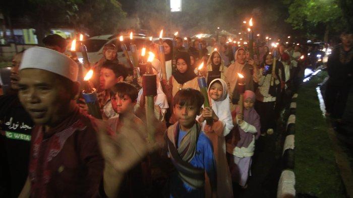 Warga dari DKM Al- Fattah Kota Cimahi melakukan pawai obor saat memperingati Tahun Baru Islam ( 1 Muharram 1446 H ) saat melintas di Jalan Gatot Subroto, Cimahi.Sabtu (6/7). Kegiatan pawai obor ini diikuti anak-anak, remaja dan orang tua dengan melantunkan solawatan.