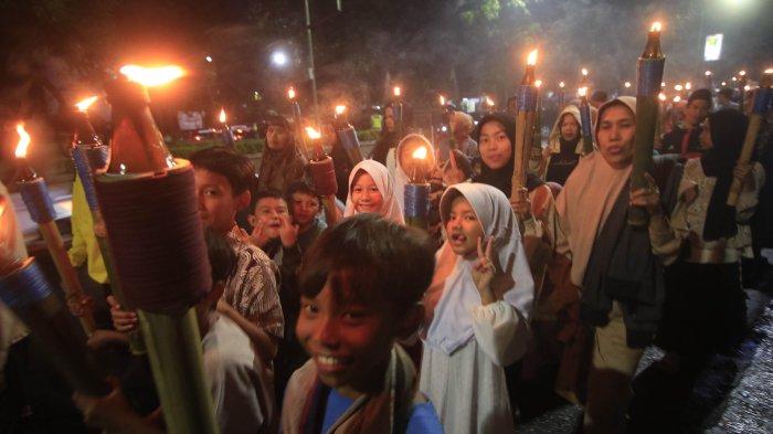 Warga dari DKM Al- Fattah Kota Cimahi melakukan pawai obor saat memperingati Tahun Baru Islam ( 1 Muharram 1446 H ) saat melintas di Jalan Gatot Subroto, Cimahi.Sabtu (6/7). Kegiatan pawai obor ini diikuti anak-anak, remaja dan orang tua dengan melantunkan solawatan.