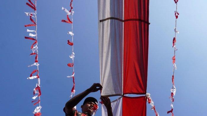 Panitia HUT ke-79 RI memasang bendera dan rarawisan merah putih di atas Jalan Kampung Mengger Hilir, RW 03, Desa Sukapura, Kecamatan Dayeuhkolot, Kabupaten Bandung, Sabtu (10/8/2024).
