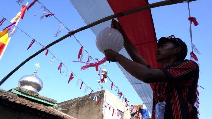 Panitia HUT ke-79 RI memasang bendera dan rarawisan merah putih dan pernak-pernik lainnya di atas Jalan Kampung Mengger Hilir, RW 03, Desa Sukapura, Kecamatan Dayeuhkolot, Kabupaten Bandung, Sabtu (10/8/2024).