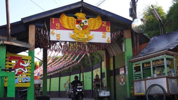 Pengendara sepeda motor melintas di Jalan Kampung Mengger Hilir yang dihiasi bendera dan rarawisan merah putih, di RW 03, Desa Sukapura, Kecamatan Dayeuhkolot Kabupaten Bandung, Sabtu (10/8/2024).