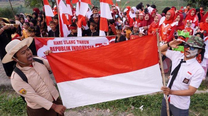 Santri dan santriwati bersama orang tuanya menyanyikan lagu Indonesia Raya saat mengikuti upacara HUT ke-79 Kemerdekaan RI, di Kampung Cilebak, RT 05 RW 02, Desa Rancamanyar, Kecamatan Baleendah, Kabupaten Bandung, Jawa Barat, Sabtu (17/8/2024).