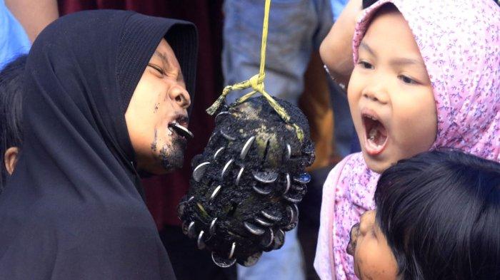 Anak-anak mengikuti lomba mengambil uang di buah pepaya menggunakan mulut di Sungai Cidurian yang diuruk tanah di saat airnya surut, di RW 16, Kelurahan Padasuka, Kecamatan Cibeunying Kidul, Kota Bandung, Jawa Barat, Sabtu (17/8/2024).