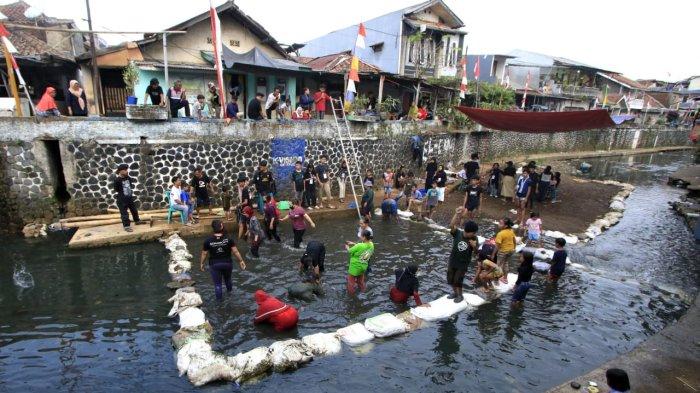 Sejumlah emak-emak mengikuti lomba gogo lauk atau menangkap ikan dengan tangan terbuka di Sungai Cidurian yang dibendung di saat airnya surut, di RW 15, Kelurahan Padasuka, Kecamatan Cibeunying Kidul, Kota Bandung, Jawa Barat, Sabtu (17/8/2024).