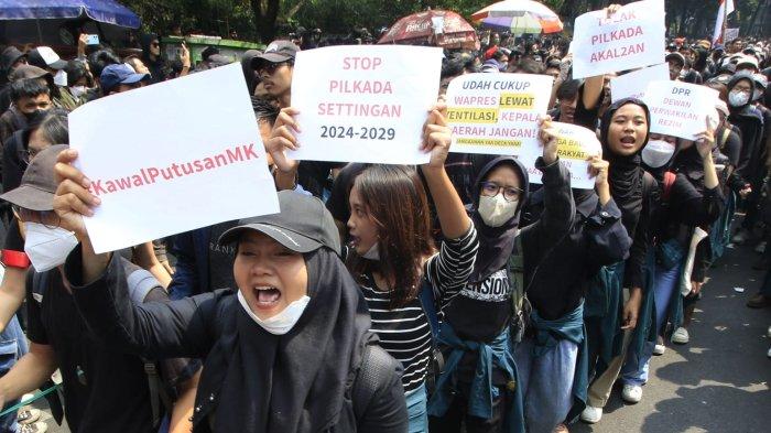 Pengunjuk rasa memegang poster saat menggelar aksi unjuk rasa Tolak Revisi UU Pilkada dan Kawal Putusan MK di depan Gedung DPRD Jawa Barat, Kota Bandung, Kamis (22/8/2024).