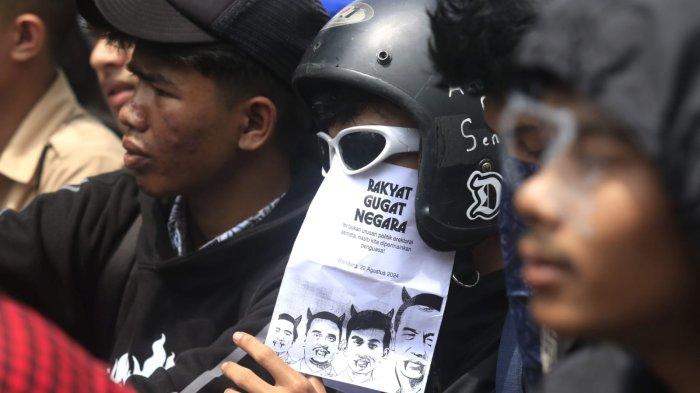 Pengunjuk rasa memegang poster saat menggelar aksi unjuk rasa Tolak Revisi UU Pilkada dan Kawal Putusan MK di depan Gedung DPRD Jawa Barat, Kota Bandung, Kamis (22/8/2024).