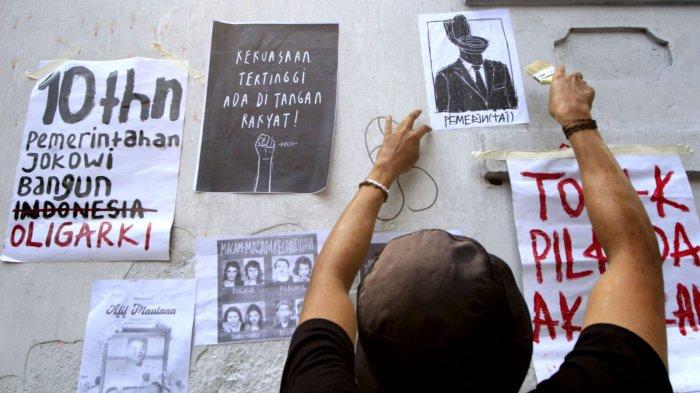 Pengunjuk rasa menempel poster di tembok pagar DPRD Jabar saat menggelar aksi unjuk rasa Tolak Revisi UU Pilkada dan Kawal Putusan MK di depan Gedung DPRD Jawa Barat, Kota Bandung, Kamis (22/8/2024).