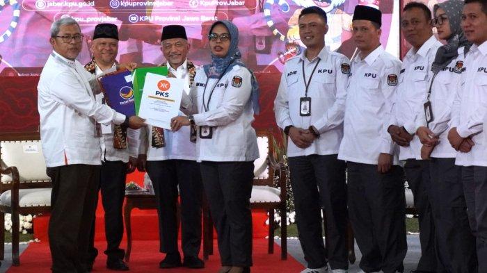 Pimpinan Tim Pengusung yang juga mantan Gubernur Jawa Barat, Ahmad Heryawan (kiri) menyerahkan berkas persyaratan pendaftaran Pilgub Jabar 2024 pasangan bakal calon gubernur dan wakil gubernur Jawa Barat, Ahmad Syaikhu - Ilham Habibie (Jabar ASIH) kepada Ketua KPU Jawa Barat, Ummi Wahyuni, di KPU Jawa Barat, Jalan Garut, Kota Bandung, Kamis (29/8/2024).