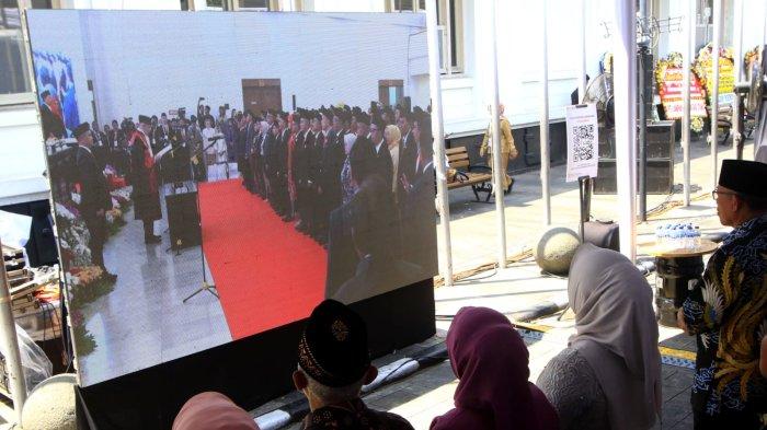 Tamu undangan yang berada di luar Gedung Merdeka menyaksikan dari layar lebar prosesi Rapat Paripurna Pelantikan Anggota DPRD Provinsi Jawa Barat Periode 2024-2029 di Jalan Ir Sukarno, Kota Bandung, Jawa Barat, Senin (2/9/2024).