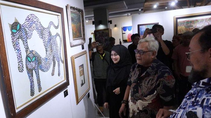 Pelukis yang juga aktor teater, Taufan S. Chandranegara (tengah) didampingi kurator pameran Aendra Medita (kanan) dan ketua panitia Moya K. Kamaruddin melihat salah satu lukisan pada Pameran Lukisan 
