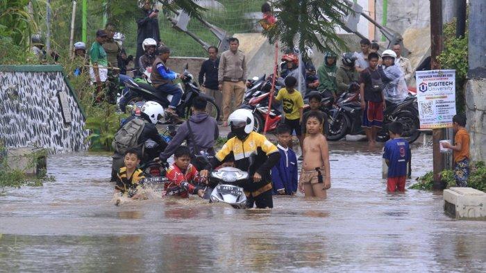 Pengendara mendorong motornya yang mogok saat nekat melintasi banjir cukup dalam di Jalan Saketi dan Jalan Pandeureusan, perbatasan Desa Rancamanyar dan Desa Cangkuang Wetan, di Kabupaten Bandung, Rabu (11/9/2024).