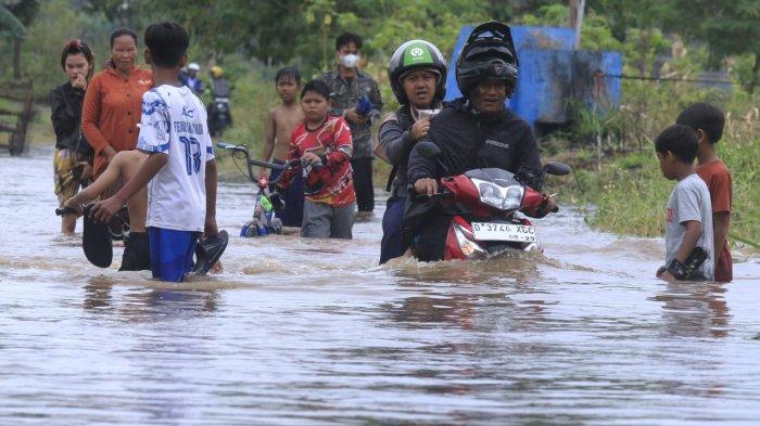 Pengendara sepeda motor nekat melintasi banjir cukup dalam di Jalan Saketi dan Jalan Pandeureusan, perbatasan Desa Rancamanyar dan Desa Cangkuang Wetan, di Kabupaten Bandung, Rabu (11/9/2024).