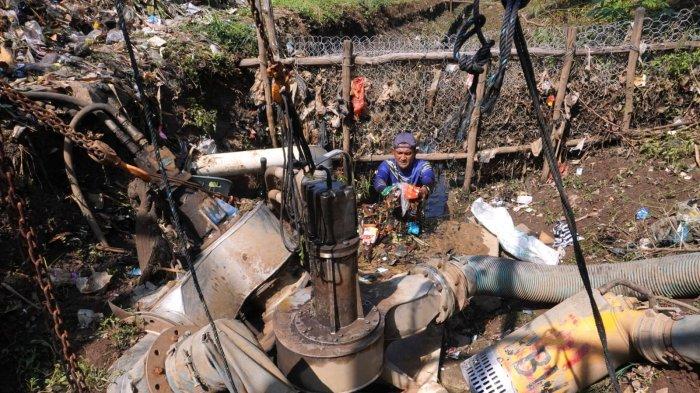 Petugas Polder Cipalasari 1, Nana Suntana (40) membersihkan sampah yang nyangkut dan menyumbat di pompa pengendali banjir Polder Cipalasari 1, Kampung Citeureup, Desa/Kecamatan Dayeuhkolot, Kabupaten Bandung, Jawa Barat, Kamis (12/9/2024).