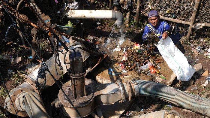 Petugas Polder Cipalasari 1, Nana Suntana (40) membersihkan sampah yang nyangkut dan menyumbat di pompa pengendali banjir Polder Cipalasari 1, Kampung Citeureup, Desa/Kecamatan Dayeuhkolot, Kabupaten Bandung, Jawa Barat, Kamis (12/9/2024).