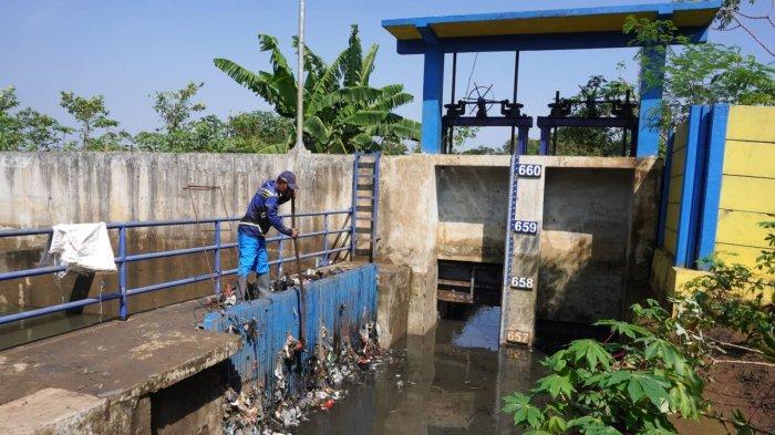 Petugas Polder Cipalasari 1, Nana Suntana (40) membersihkan sampah yang nyangkut dan menyumbat di besi penyaringan kolam penampungan air pengendali banjir Polder Cipalasari 1, Kampung Citeureup, Desa/Kecamatan Dayeuhkolot, Kabupaten Bandung, Jawa Barat, Kamis (12/9/2024).