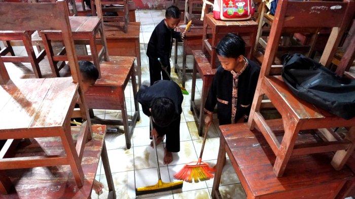 Sejumlah siswa mengepel lantai di salah satu ruangan kelas pasca banjir di SDN Bojongasih 02, Jalan Tubagus Anom, Kampung Bojongasih, Desa/Kecamatan Dayeuhkolot, Kabupaten Bandung, Jawa Barat, Kamis (12/9/2024).