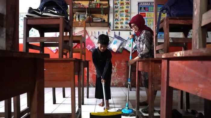 Siswa dan guru mengepel lantai di salah satu ruangan kelas pasca banjir di SDN Bojongasih 02, Jalan Tubagus Anom, Kampung Bojongasih, Desa/Kecamatan Dayeuhkolot, Kabupaten Bandung, Jawa Barat, Kamis (12/9/2024).