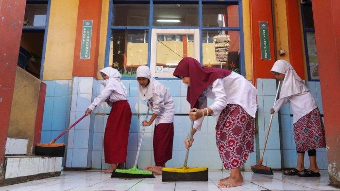 Sejumlah siswa membuang sisa air di teras pasca banjir di SDN Bojongasih 02, Jalan Tubagus Anom, Kampung Bojongasih, Desa/Kecamatan Dayeuhkolot, Kabupaten Bandung, Jawa Barat, Kamis (12/9/2024).
