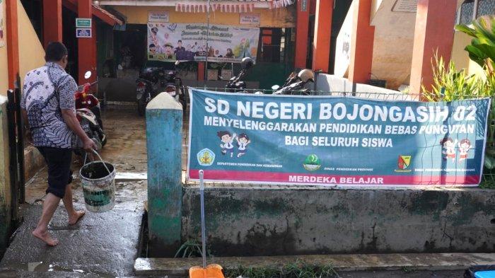 Kepala SDN Bojongasih 02, Deni Gunadi membersihkan halaman sekolah pasca banjir di SDN Bojongasih 02, Jalan Tubagus Anom, Kampung Bojongasih, Desa/Kecamatan Dayeuhkolot, Kabupaten Bandung, Jawa Barat, Kamis (12/9/2024).