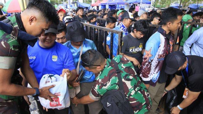 Bobotoh diperiksa petugas di pintu masuk stadion saat akan menyaksikan pertandingan Persib Bandung menghadapi Persija dalam lanjutan Liga 1 2024-2025 di Stadion Si Jalak Harupat, Senin (23/9/2024).