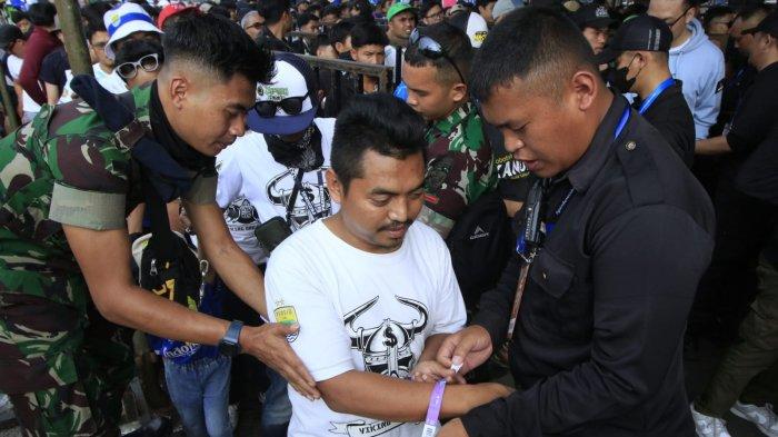 Bobotoh diperiksa petugas di pintu masuk stadion saat akan menyaksikan pertandingan Persib Bandung menghadapi Persija dalam lanjutan Liga 1 2024-2025 di Stadion Si Jalak Harupat, Senin (23/9/2024).