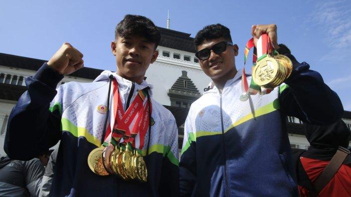 Atlet dayung Jawa Barat, Rudiyansyah (kanan) dan Ikballana Ikhsan memperlihatkan medali yang telah mereka raih pada acara penyambutan kontingen Jabar yang sudah berlaga di Pekan Olahraga Nasional (PON) XXI 2024 Aceh - Sumatera Utara, di halaman Gedung Sate, Kota Bandung, Jawa Barat, Kamis (26/9/2024).