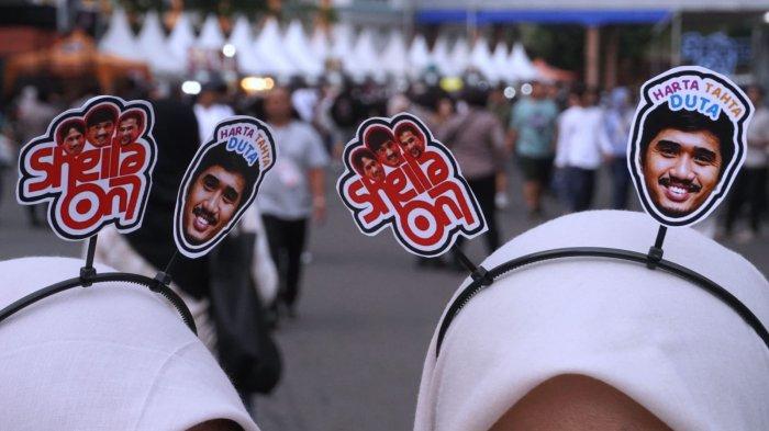 Penggemar Sheila On 7 (Sheila Gank) mengenakan bandana bergambar foto Duta, Eross, dan Adam saat akan menyaksikan konser Sheila On 7 bertajuk 
