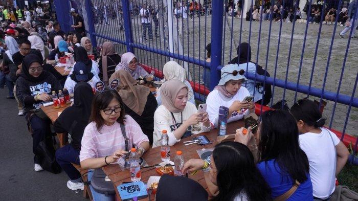 Penggemar Sheila On 7 (Sheila Gank) menikmati makan dan minum di luar stadion sebelum menyaksikan konser Sheila On 7 bertajuk 