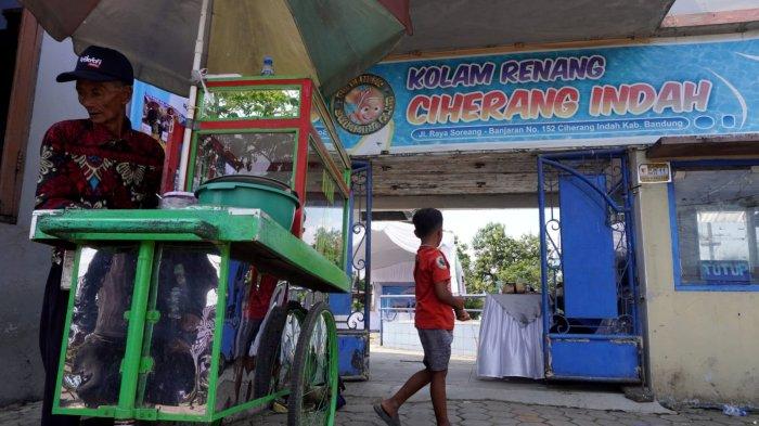 Pedagan berjualan di pintu masuk Kolam Renang Ciherang Indah yang sudah tidak beroperasi lagi, di Jalan Raya Soreang - Banjaran, Desa Kamasan, Kecamatan Banjaran, Kabupaten Bandung, Jawa Barat, Rabu (10/10/2024).