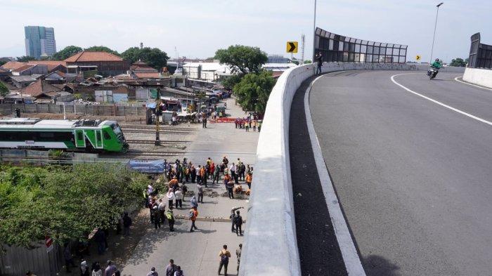 Kendaraan bermotor melintas di Flyover Coroyom setelah resmi dibuka dan sejumlah petugas dan pekerja sedang menutup perlintasan sebidang Kereta Api di Ciroyom, Kota Bandung, Jawa Barat, Rabu (23/10/2024).