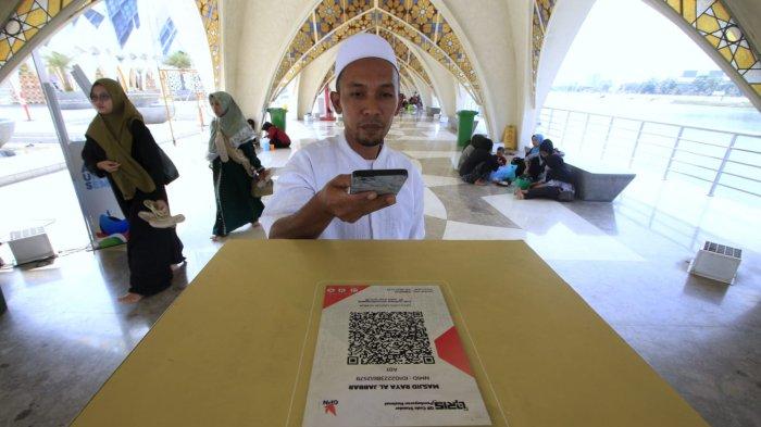 Jemaah berinfaq dan bersedekah secara non-tunai dengan menggunakan QRIS (Quick Response Code Indonesian Standard) di Masjid Al-Jabbar, Kota Bandung, Jawa Barat, Senin (28/10/2024).