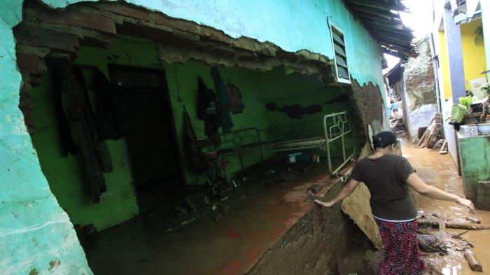 Pemilik rumah melintas di samping dinding rumahnya yang amrol pascabanjir bandang menerjang rumahnya, di Kampung Muara, Desa Banjaran Wetan, Kecamatan Banjaran, Kabupaten Bandung, Jawa Barat, Rabu (6/11/2024).