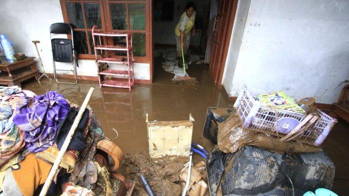 Pemilik rumah membuang lumpur yang tersisa di dalam rumah pascabanjir bandang menerjang rumahnya, di Kampung Muara, Desa Banjaran Wetan, Kecamatan Banjaran, Kabupaten Bandung, Jawa Barat, Rabu (6/11/2024).