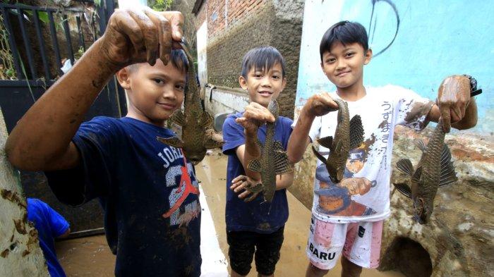 Sejumlah anak kecil menangkap ikan sapu di halaman rumahnya yang masih tergenang air pascabanjir bandang menerjang rumahnya, di Kampung Muara, Desa Banjaran Wetan, Kecamatan Banjaran, Kabupaten Bandung, Jawa Barat, Rabu (6/11/2024).