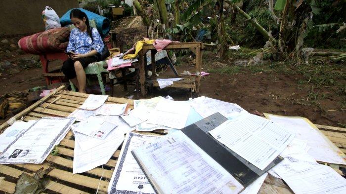 Seorang warga menjemur ijazah, buku tabungan dan dokumen lainnya pascabanjir bandang menerjang rumahnya, di Kampung Muara, Desa Banjaran Wetan, Kecamatan Banjaran, Kabupaten Bandung, Jawa Barat, Rabu (6/11/2024).
