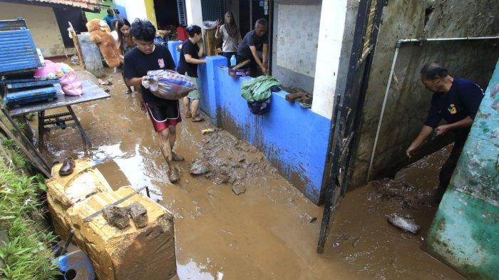 Sejumlah warga membuang lumpur di rumahnya dan warga lainnya membawa barang-barang untuk mengungsi karena rumahnya sudah tidak layak ditempati lagi karena temboknya ambrol pascabanjir bandang menerjang rumahnya, di Kampung Muara, Desa Banjaran Wetan, Kecamatan Banjaran, Kabupaten Bandung, Jawa Barat, Rabu (6/11/2024).