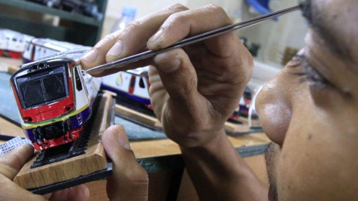 Perajin mengerjakan proses pembuatan miniatur kereta api di Jalan Haji Haris, Kelurahan Baros, Kecamatan Cimahi Tengah, Kota Cimahi, Senin (9/12/2024).