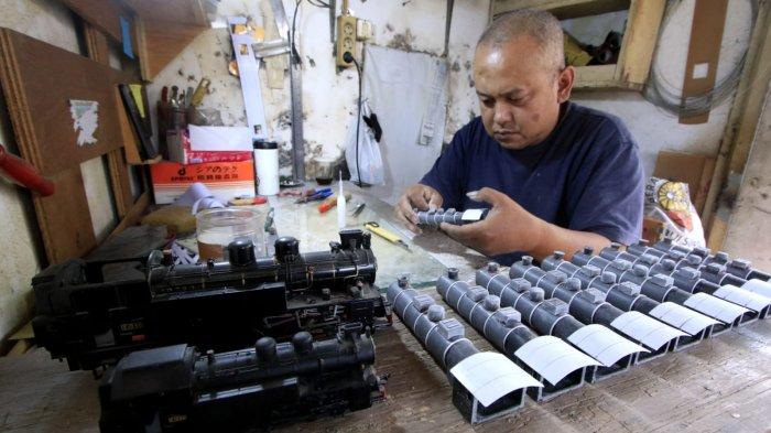 Perajin mengerjakan proses pembuatan miniatur kereta api di Jalan Haji Haris, Kelurahan Baros, Kecamatan Cimahi Tengah, Kota Cimahi, Senin (9/12/2024).